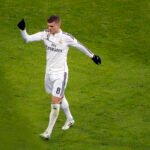 Photo by Capitalist Money on June 16, 2024. May be an image of A male soccer player in a white uniform with the number 8 on his shorts, giving a thumbs up to the crowd. The background is a lush green soccer field. The image may contain text such as 'Fly Emirates', '8', 'RM'.