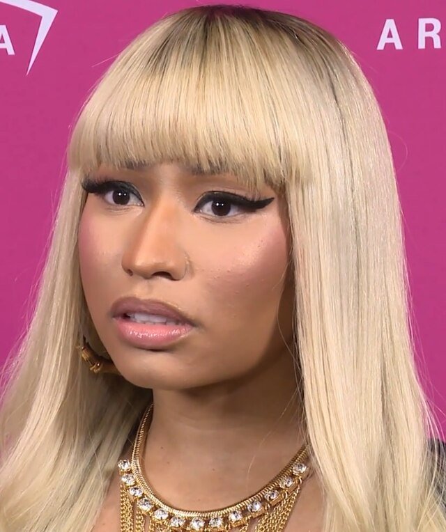 Photo by Capitalist Money on June 16, 2024. May be an image of Close-up of Nicki Minaj with blonde hair and a gold necklace, her expression is serious. The image may contain text such as 'AR'.