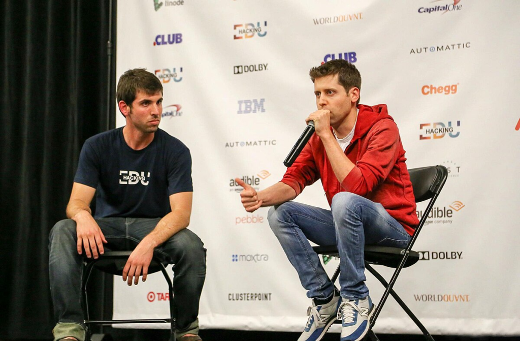 Photo by Capitalist Money on June 16, 2024. May be an image of Two men are sitting on chairs in front of a backdrop with company logos. One man is speaking into a microphone while the other listens. The image may contain text such as 'Linode', 'CLUB', 'EDU', 'HACKING', 'WORLDOUVNT', 'CapitalOne', 'AUTOMATTIC', 'DOLBY', 'IBM', 'Chegg', 'audible', 'an amazon company', 'pebble', 'moxira', 'CLUSTERPOINT', 'DOLBY.', 'WORLDOUVNT.', 'OTAR'.