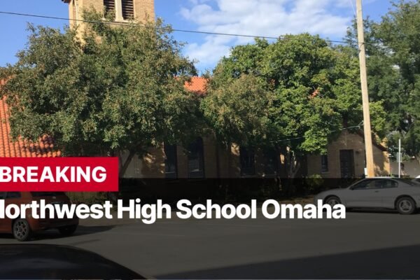 Photo by Capitalist Money on September 11, 2024. May be an image of The image shows a Northwest High School in Omaha. There is a large building in the background with a red tile roof, a large tree in front of the building, and a car parked in the front of the building. The image is taken from the street level and the school is in the background. The image may contain text such as 'BREAKING Northwest High School Omaha'.