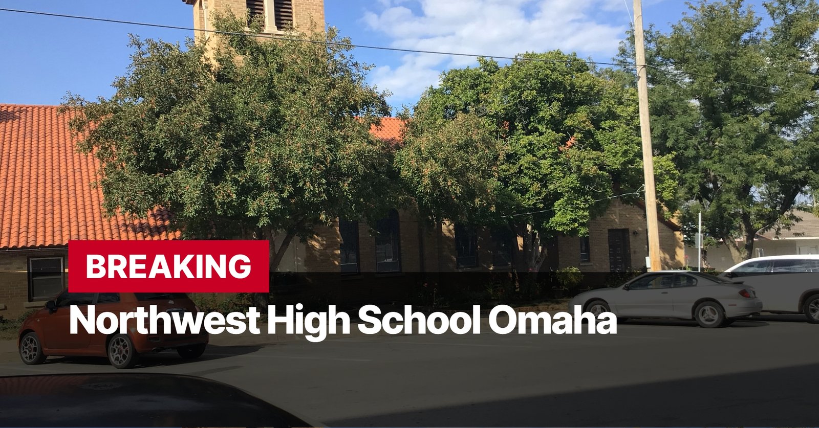 Photo by Capitalist Money on September 11, 2024. May be an image of The image shows a Northwest High School in Omaha. There is a large building in the background with a red tile roof, a large tree in front of the building, and a car parked in the front of the building. The image is taken from the street level and the school is in the background. The image may contain text such as 'BREAKING Northwest High School Omaha'.