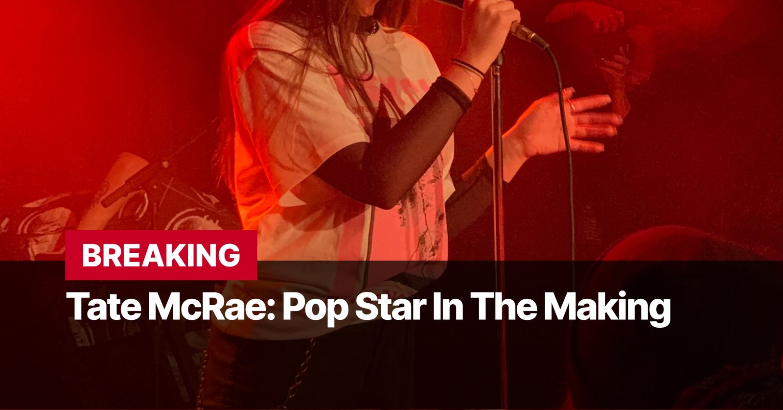 Photo by Capitalist Money on September 12, 2024. May be an image of A young woman sings into a microphone on stage in a red lit venue. The image may contain text such as 'BREAKING Tate McRae: Pop Star In The Making'.