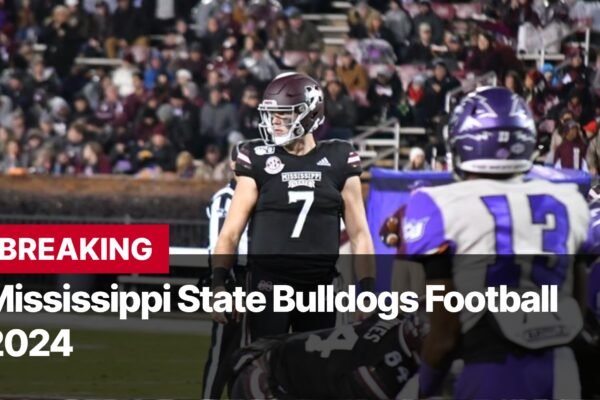 Photo by Capitalist Money on September 08, 2024. May be an image of A football player in a black jersey with the number 7 on it stands on a football field, surrounded by fans. He is wearing a maroon helmet and maroon and white pants. The image may contain text such as 'BREAKING Mississippi State Bulldogs Football 2024'.