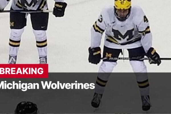 Photo by Capitalist Money on September 15, 2024. May be an image of A Michigan Wolverines hockey player on the ice, wearing a white jersey with a black and yellow M. The player is skating towards the camera, with the puck on the ice in front of them. The image may contain text such as 'BREAKING Michigan Wolverines'.