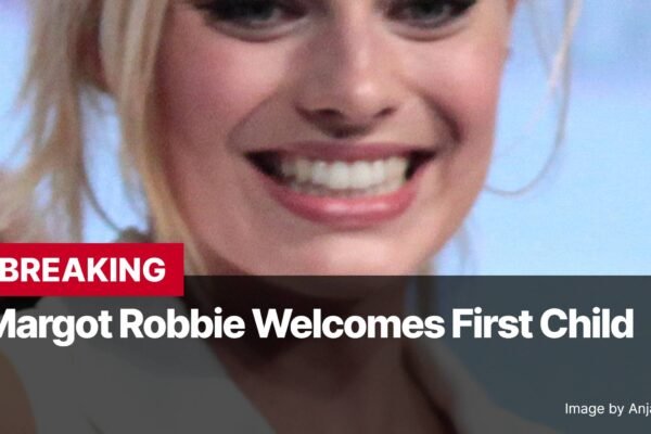 Photo by Capitalist Money on November 04, 2024. May be an image of Margot Robbie is seen smiling in this close-up image. Her blonde hair and bright smile are captured in the photo. The image may contain text such as 'BREAKING Margot Robbie Welcomes First Child Image by Anjaagnieszka'.