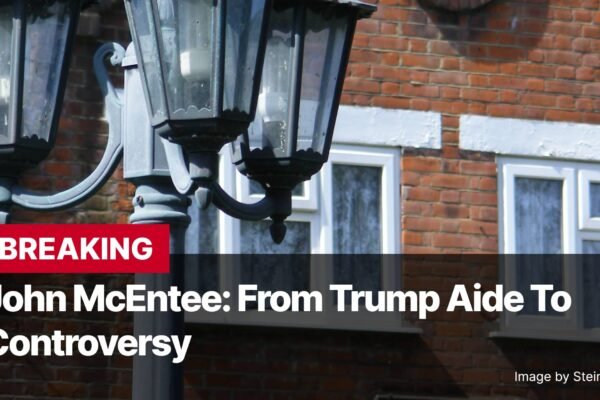 Photo by Capitalist Money on November 07, 2024. May be an image of A close-up of a street lamp in front of a brick building with two windows. The image is accompanied by a headline that reads 'BREAKING' and 'John McEntee: From Trump Aide To Controversy' The image may contain text such as 'BREAKING', 'John McEntee: From Trump Aide To', 'Controversy', 'Image by SteinsplitterBot'.